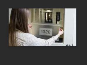 Woman using a digital doorbell with a screen displaying '1320'.