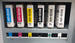 Set of Roland Eco-UV ink cartridges in various colors on a gray background.