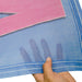 Hand holding a piece of blue and pink woven fabric