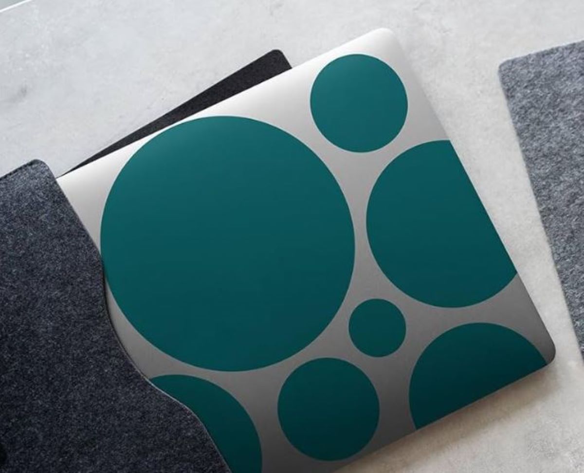 Notebook with teal circular patterns on a gray surface