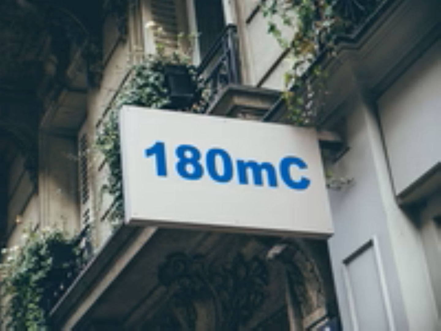 Building facade with a sign displaying '180mC'