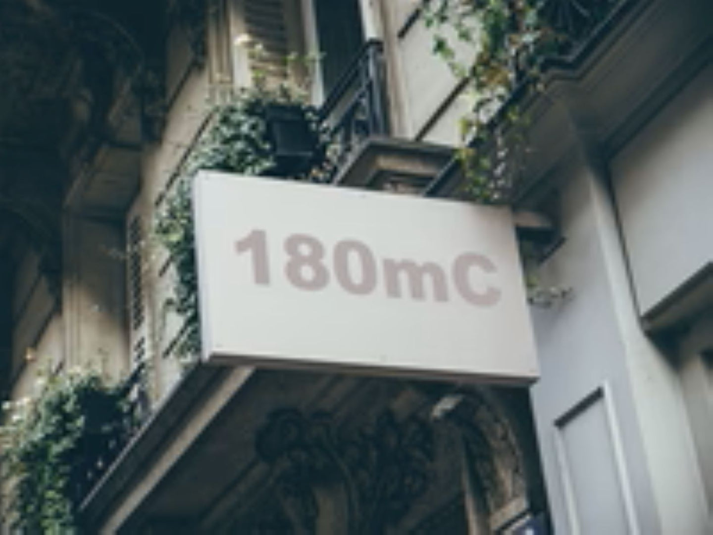Building facade with a sign displaying '180mC'