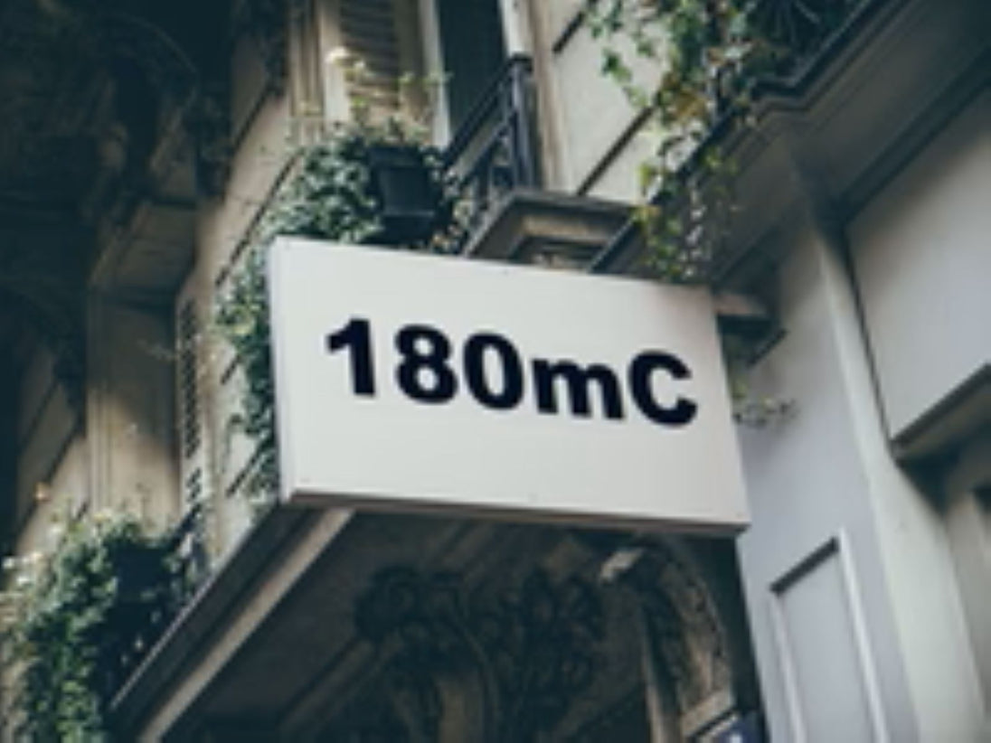Building facade with a sign displaying '180mC'