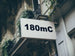 Building facade with a sign displaying '180mC'