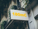 Building facade with a sign displaying '180mC' in yellow text.