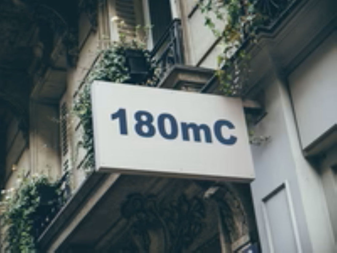 Building facade with a sign displaying '180mC'.