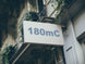 Building facade with a sign displaying '180mC'