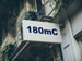 Building facade with a sign displaying '180mC'