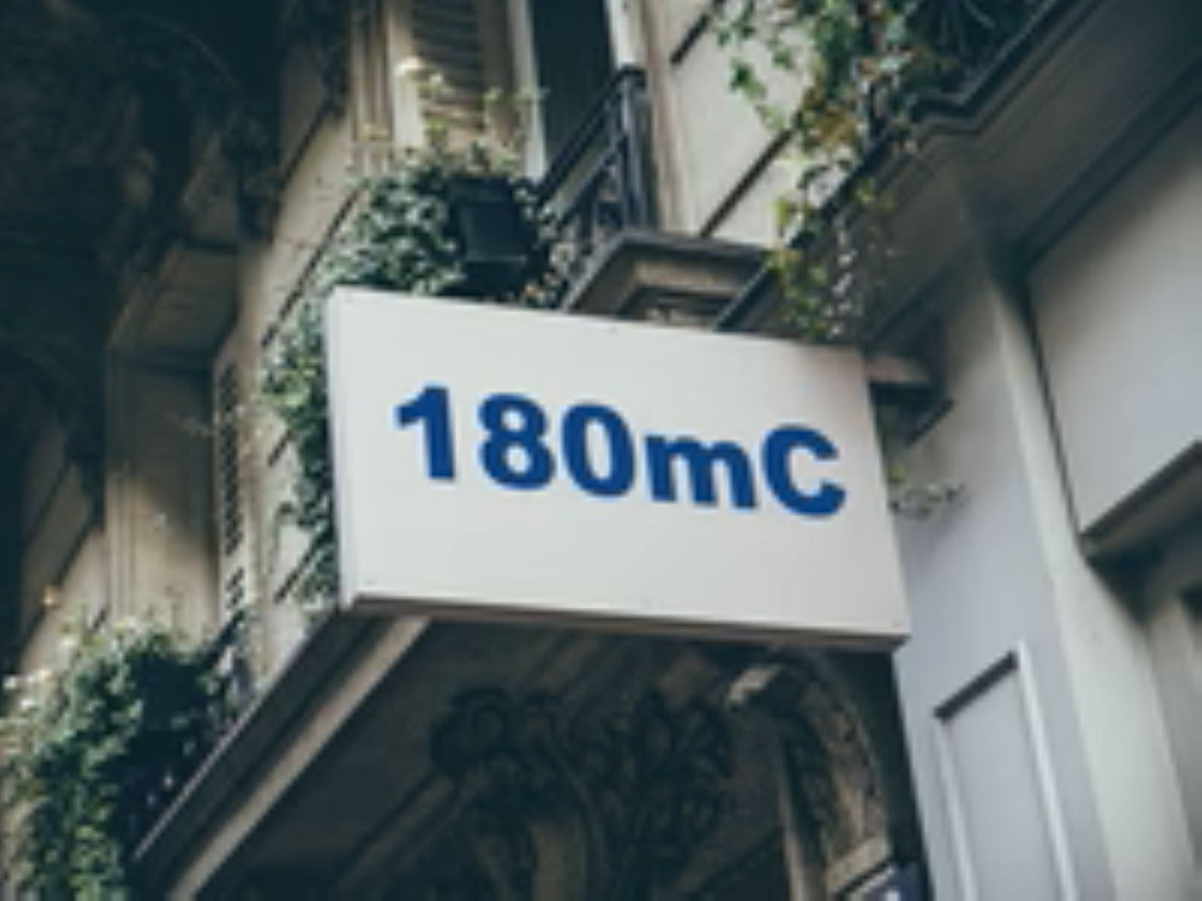 Building facade with a sign displaying '180mC'.