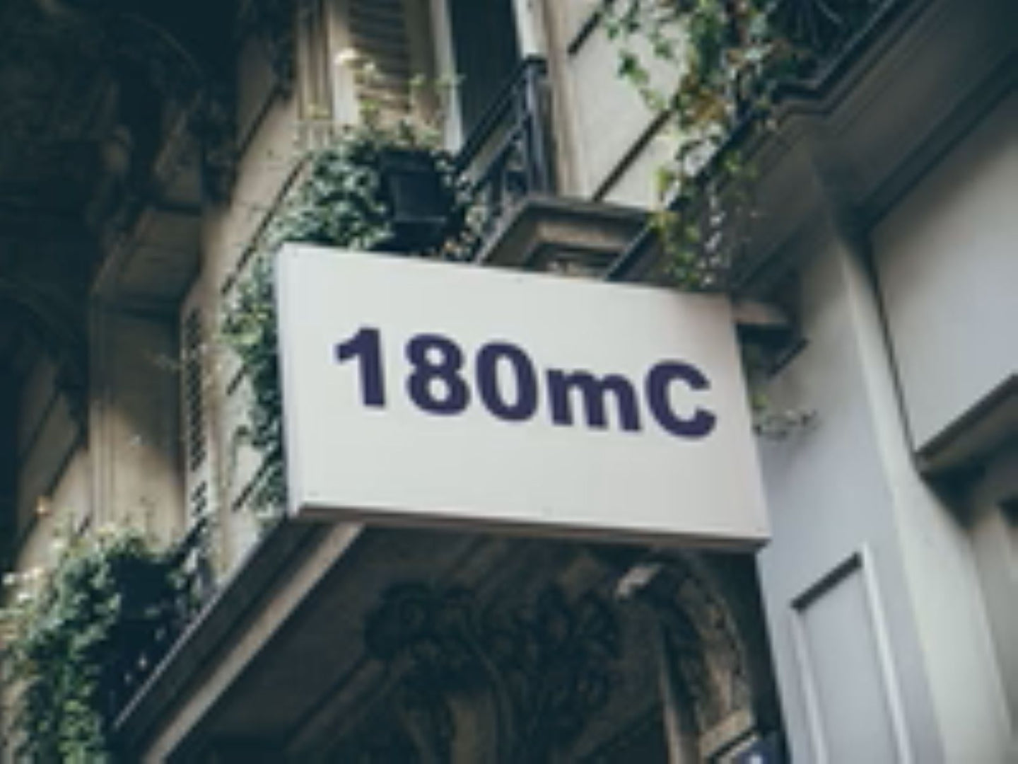 Building facade with a sign displaying '180mC'