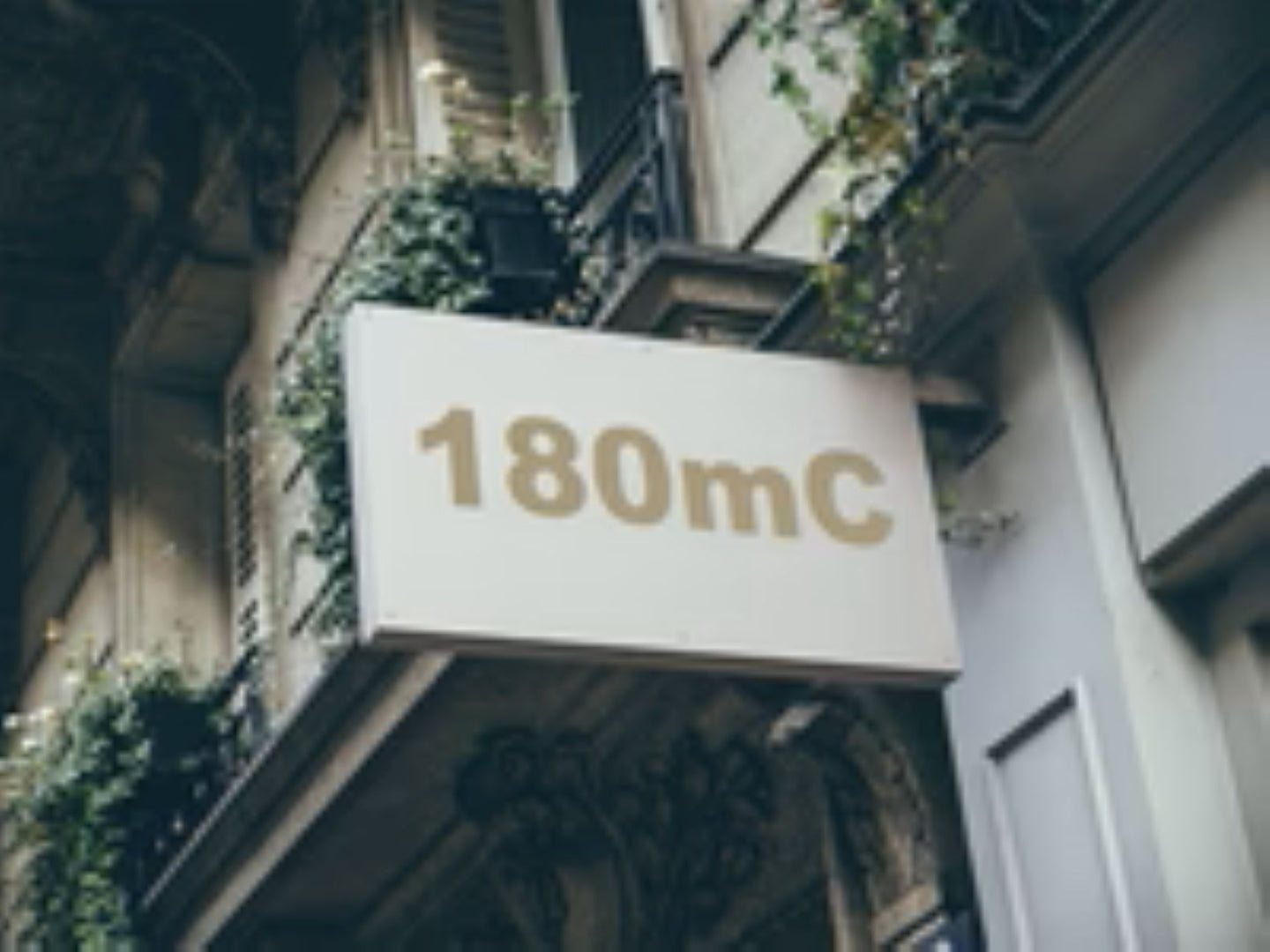 Building facade with a sign displaying '180mC'