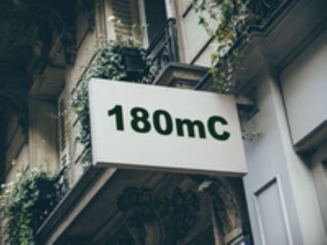 Building facade with a sign displaying '180mC'
