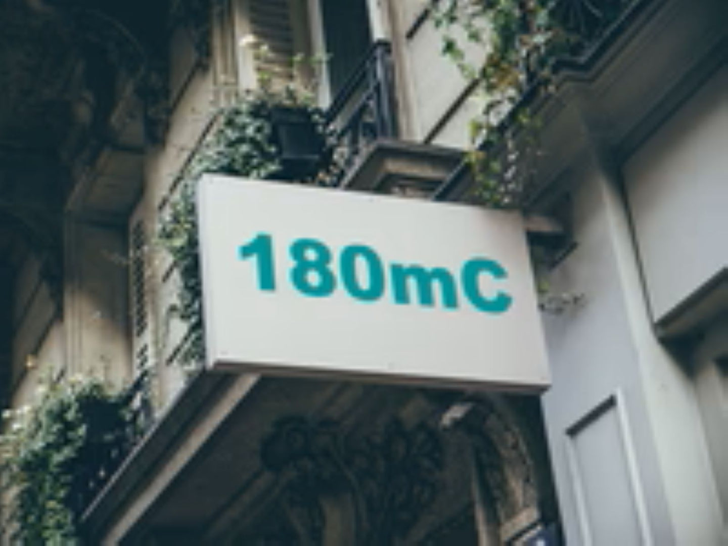 Building facade with a sign displaying '180mC'