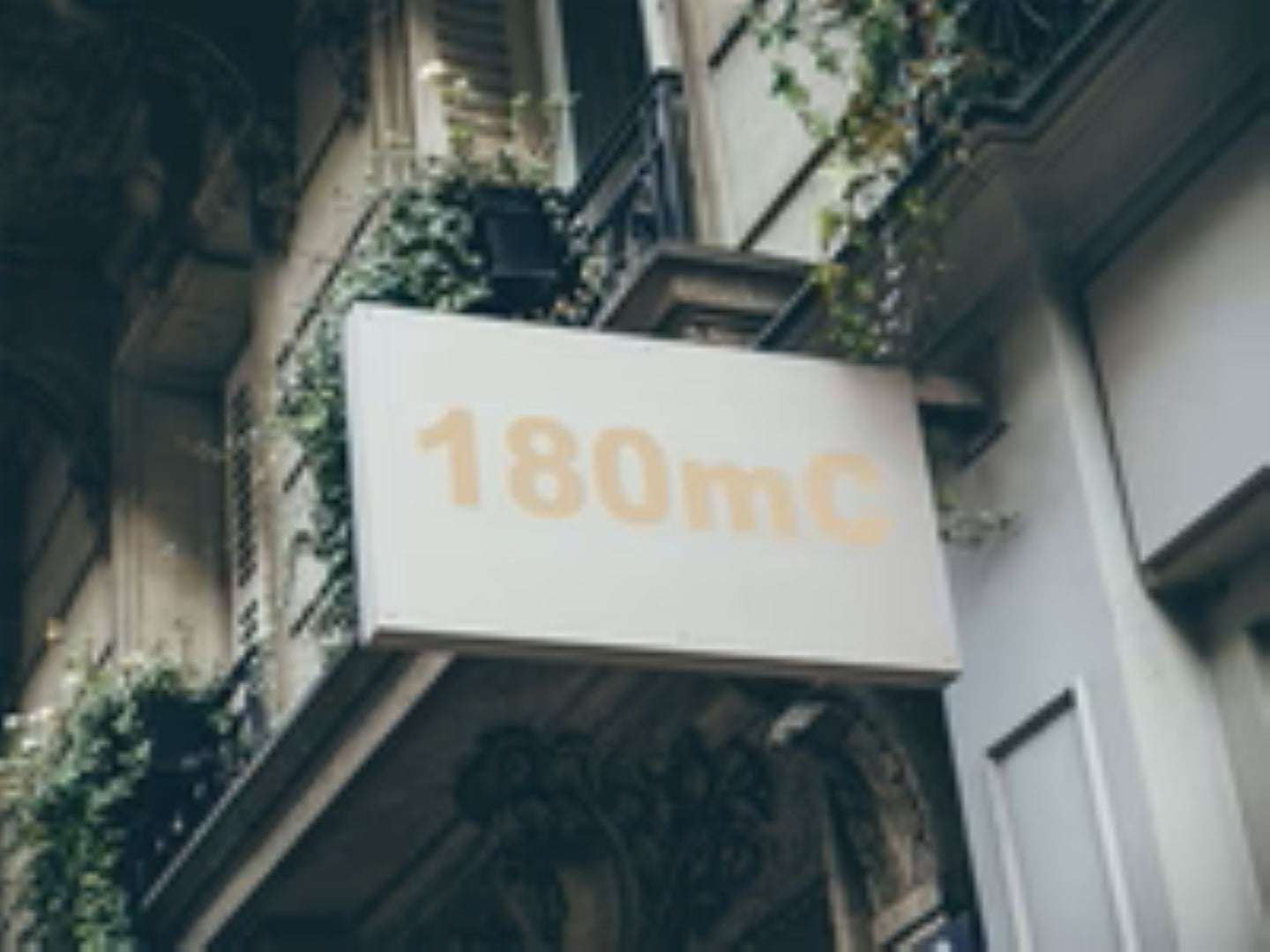 Building facade with a sign displaying '180mC'