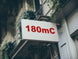 Building facade with a sign displaying '180mC' in red text.