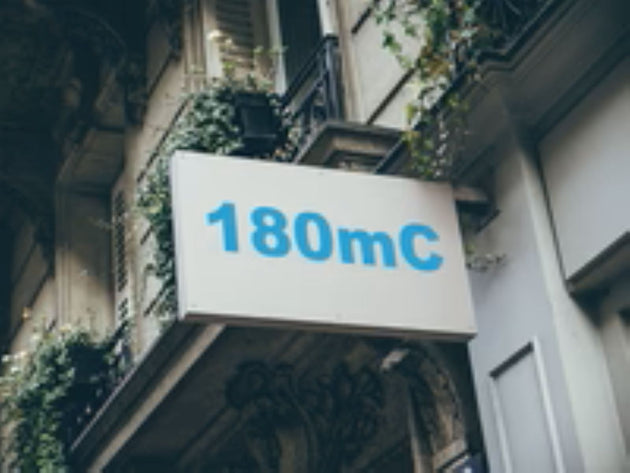 Building facade with a sign displaying '180mC' in blue text.