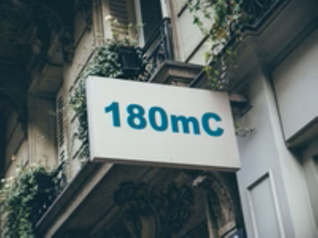 Building facade with a sign displaying '180mC'.