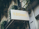 Building facade with a sign displaying '180mC' in gold lettering.