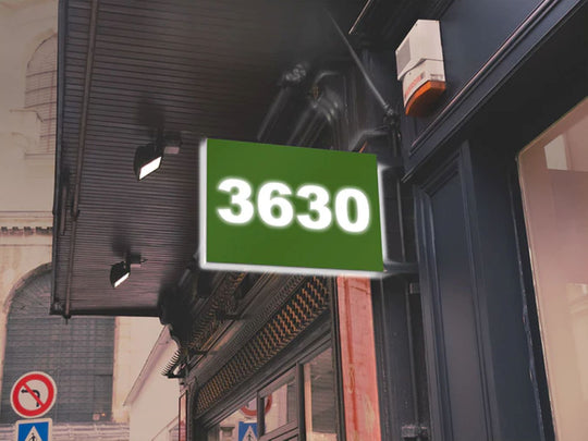 Green sign with the number 3630 on a building exterior