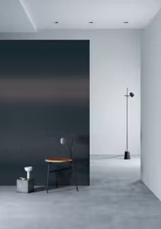 Modern interior with a black mirror leaning against a white wall.