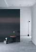 Modern interior with a black mirror leaning against a white wall.