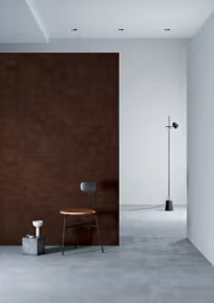 Modern interior with a brown wall, white floor, and minimal furniture.