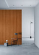 Modern interior with wooden panel wall, gray floor, and minimal furniture.
