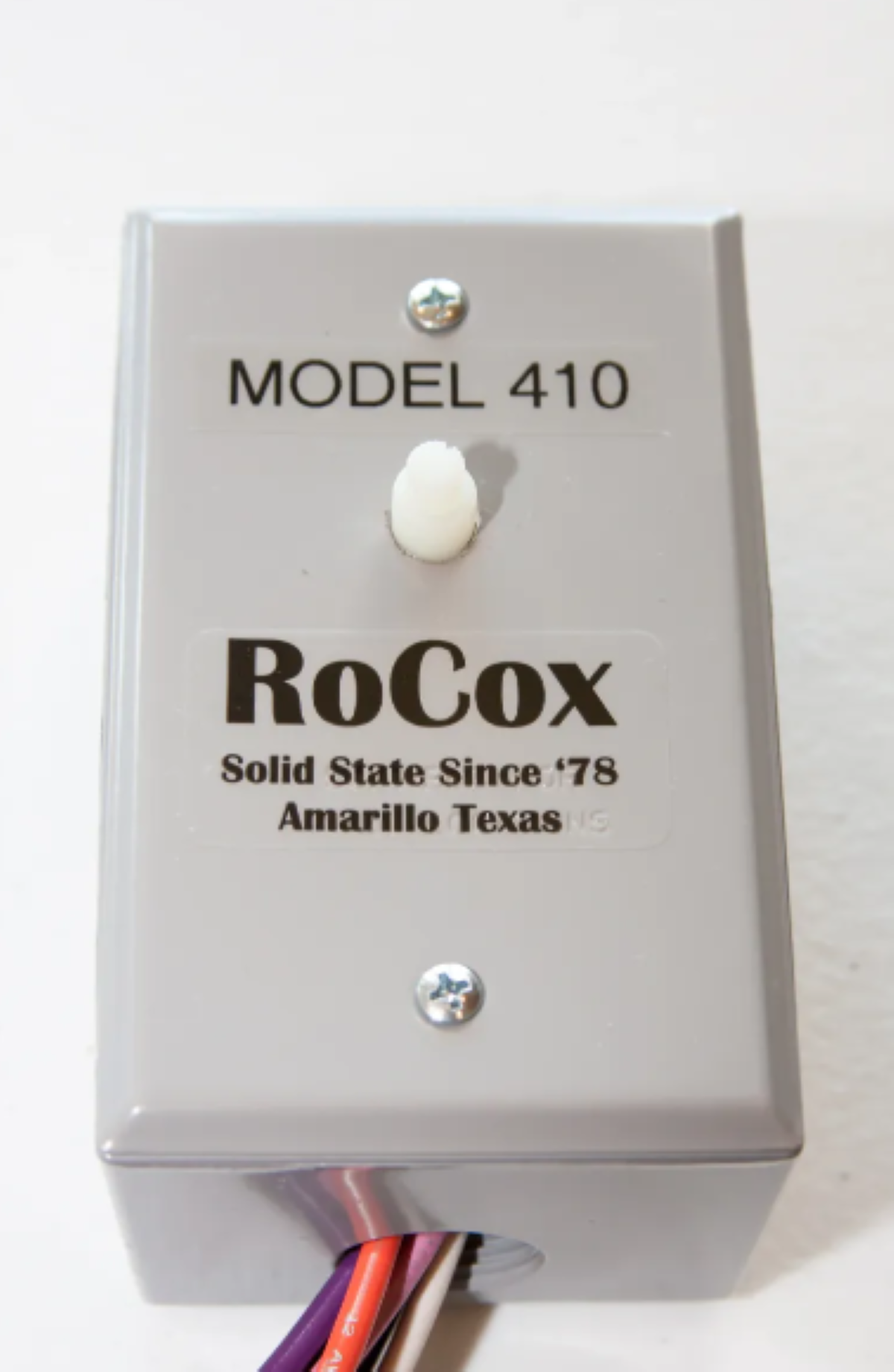 RoCox Model 410 solid state device with a white switch on a white background