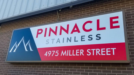 Pinnacle Stainless sign on a brick building