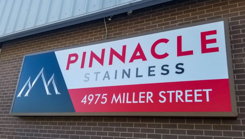 Pinnacle Stainless sign on a brick building