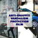Person applying anti-graffiti vandalism protection film on a glass surface.
