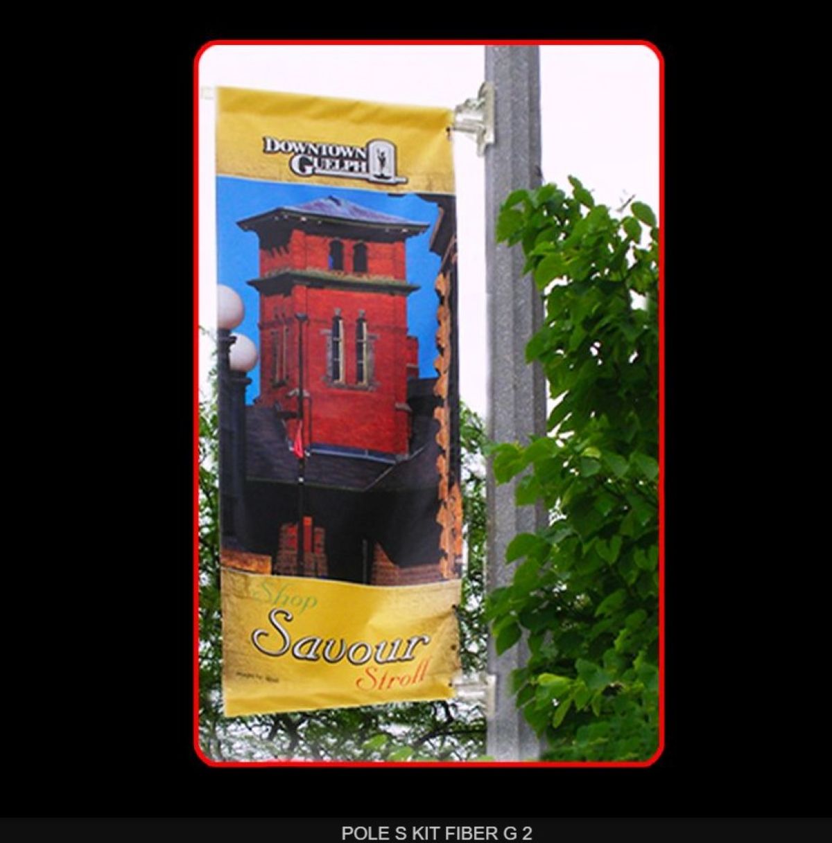 Banner with a red building design and 'Downtown Guild' text on a pole with greenery.