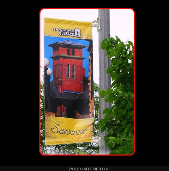 Banner with a red building design and 'Downtown Guild' text on a pole with greenery.