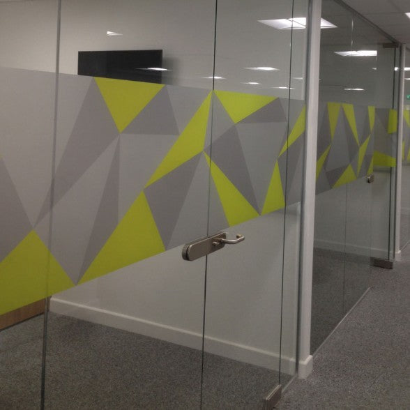 Glass door with geometric yellow and gray pattern on a wall