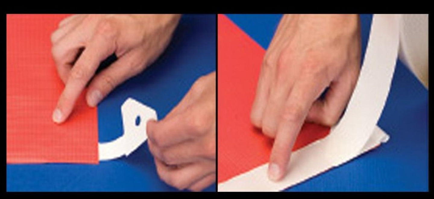 Two hands interacting with a white plastic component on a blue surface.