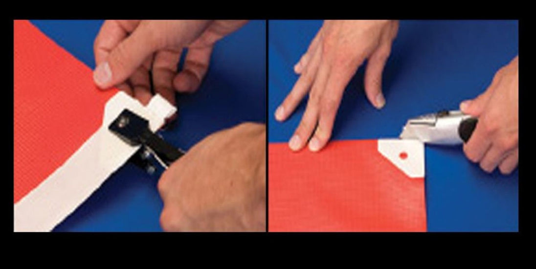 Two hands using a tool to cut red and white paper on a blue background.