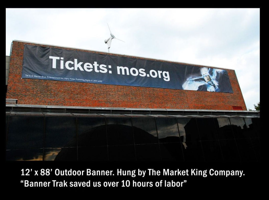 Large outdoor banner on a building with text and a website URL.