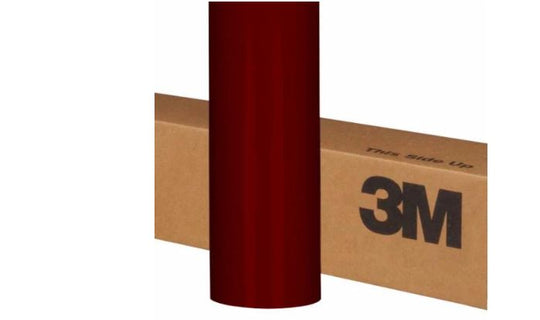 Roll of burgundy vinyl wrap with a cardboard box labeled '3M' on a white background
