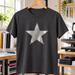 AI application illustration: silver metal-flake-style star on a charcoal T-shirt; representative finish and color.