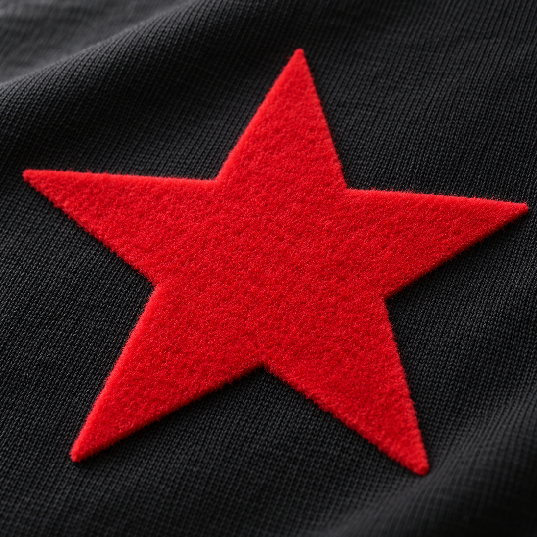 AI application illustration: raised red velour-style flock star on black fabric; representative texture and color.