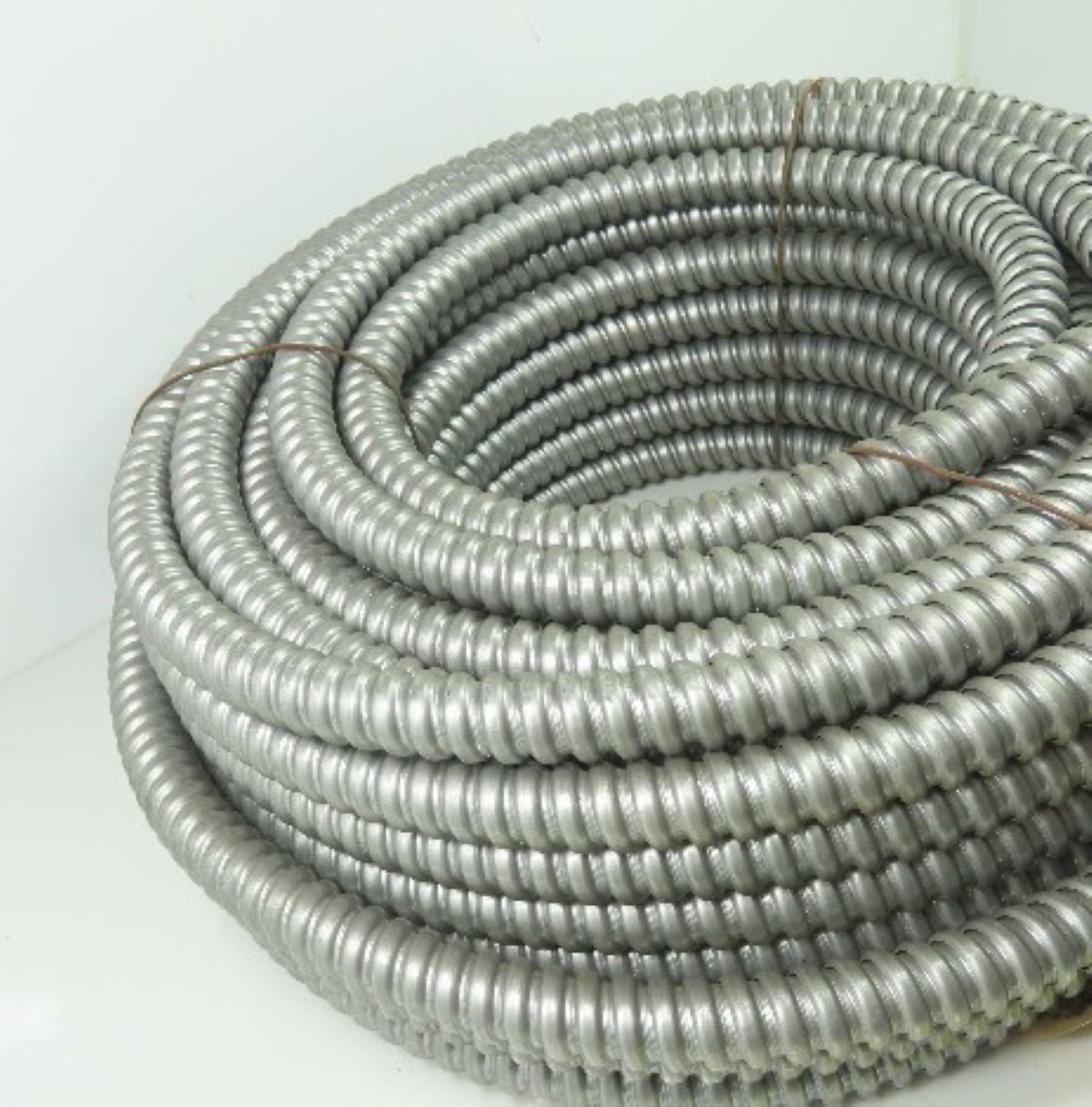 Coiled metal hose on a white background