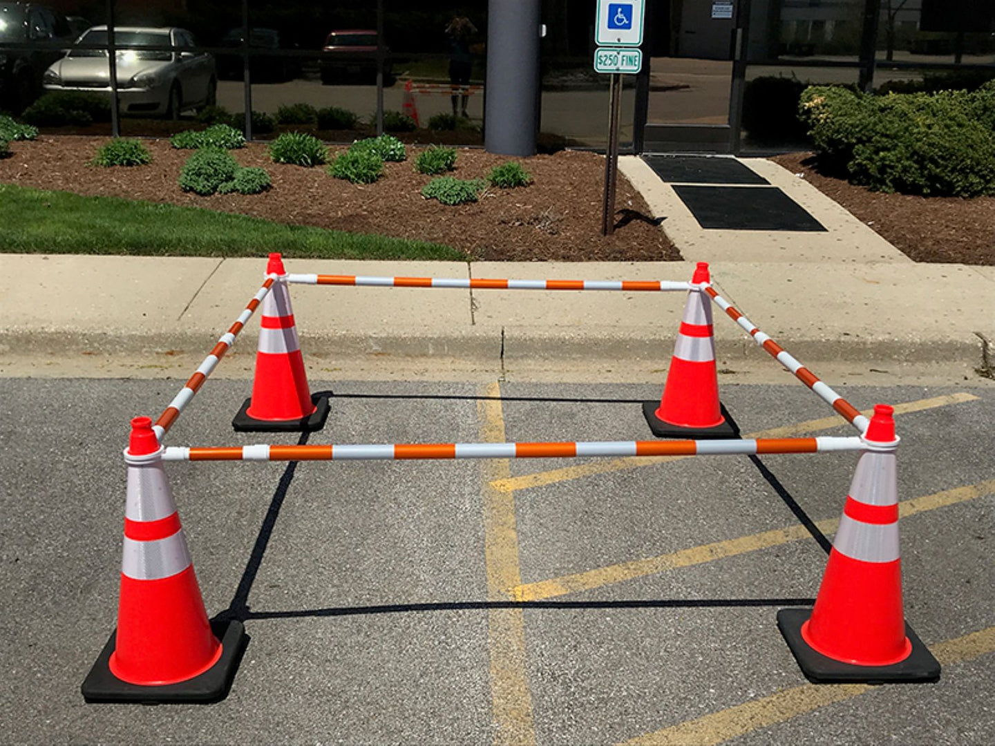 Orange traffic cones with white stripes set up in a parking lot.