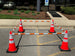 Orange traffic cones with white stripes set up in a parking lot.