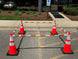 Orange traffic cones with white stripes set up in a parking lot.