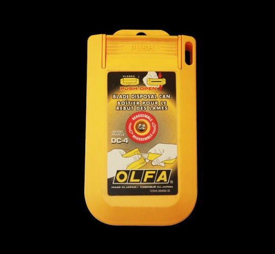 Yellow OLFA blade disposal can on a black background