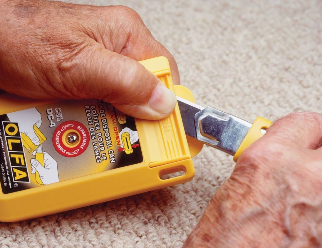 Person using a Olfa knife on a carpet with a close-up view of the tool.