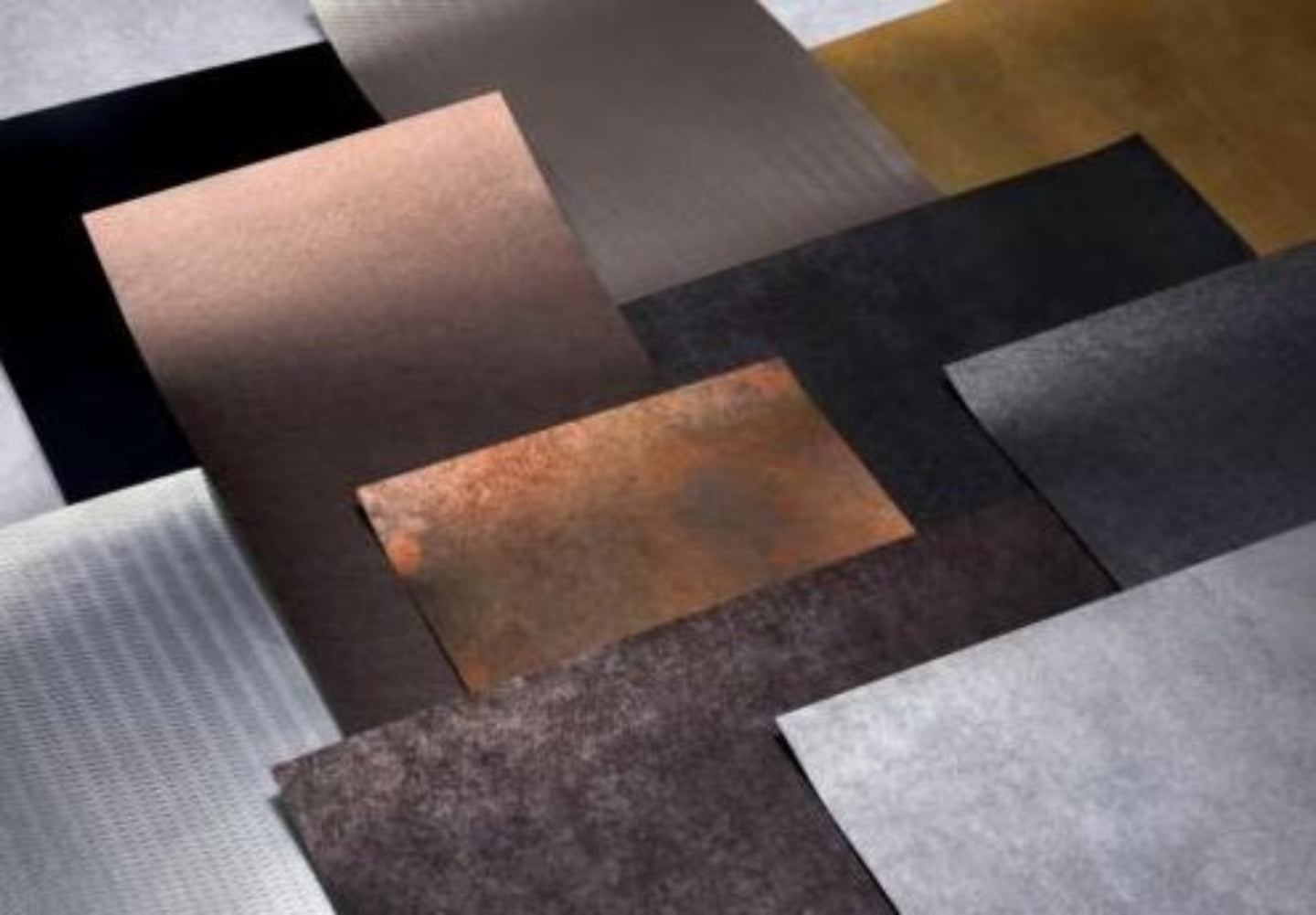 Collection of various textured metal sheets in different colors.