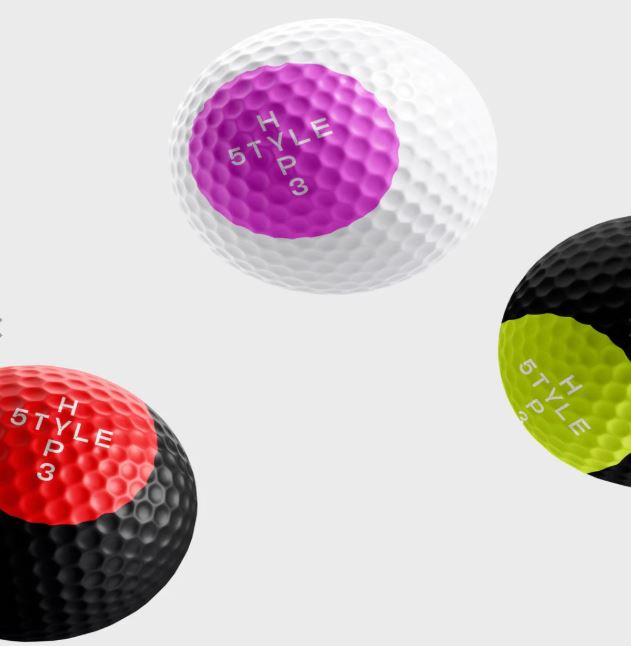 Four golf balls with different colored centers on a white background