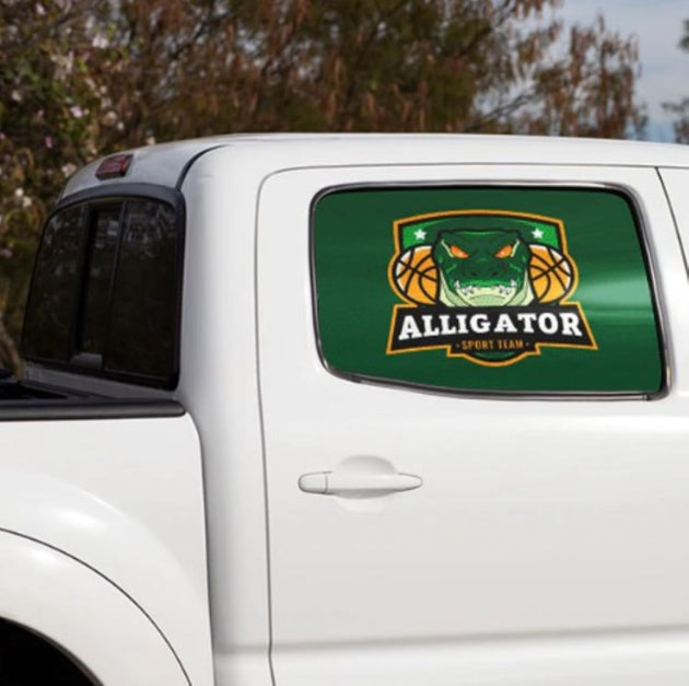 Car window with an Alligator Sport Team logo decal on a white vehicle.