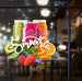 Three colorful smoothie jars with fruits and a blurred restaurant interior.